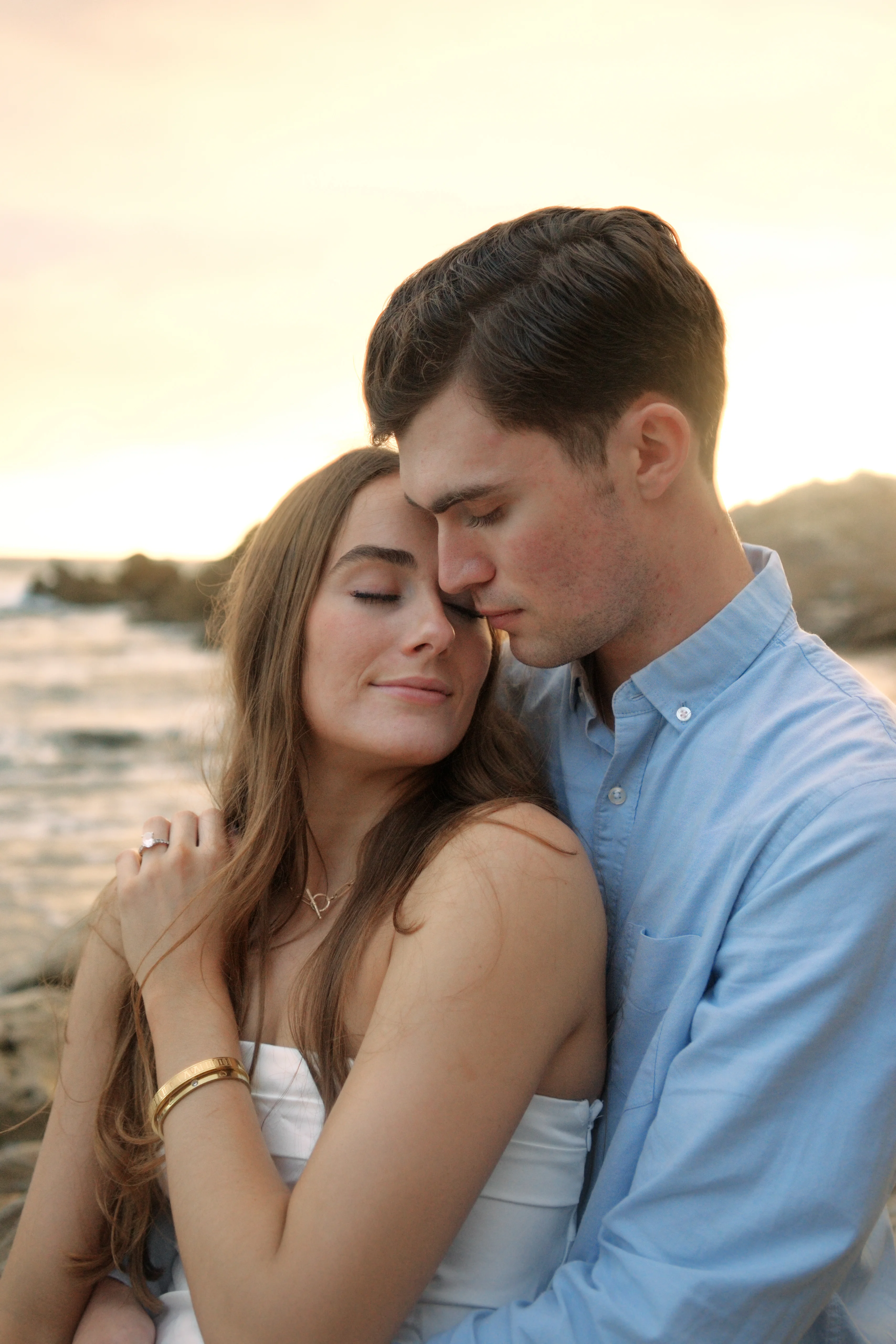 Engaged couple embracing at sunset on an Orange County beach — engagement photography by Hunter Cannon Studio