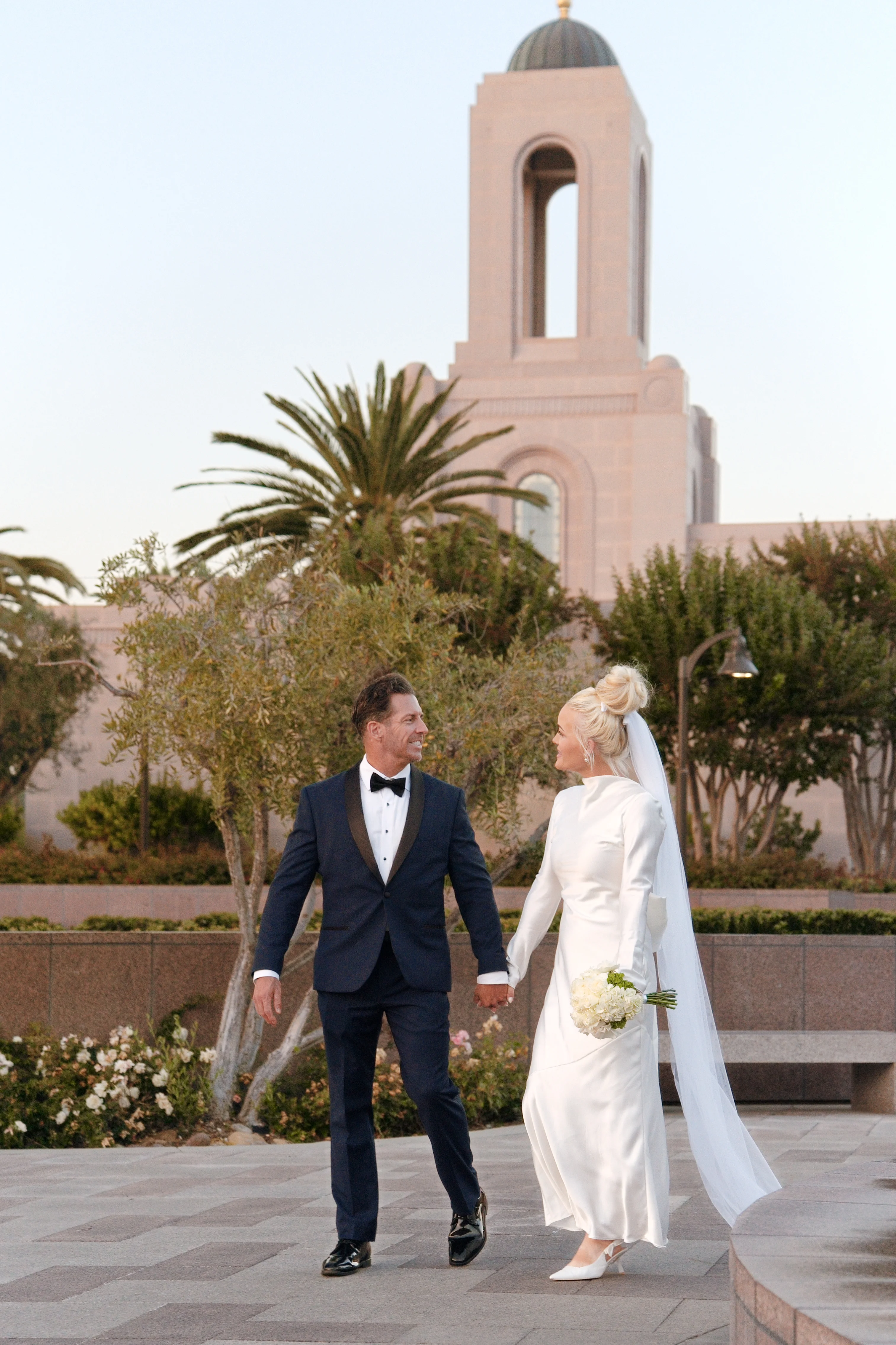 Bride and groom walking out of the Newport Beach California Temple just married